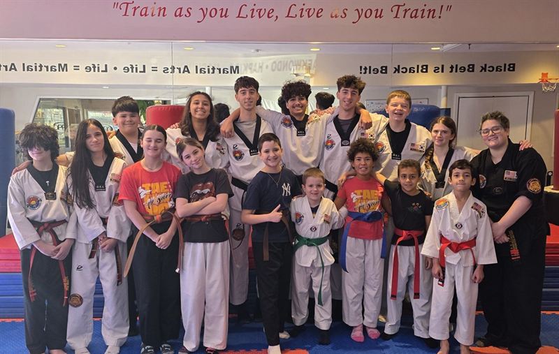 Students performing high-kicking class training under Master Ed's supervision